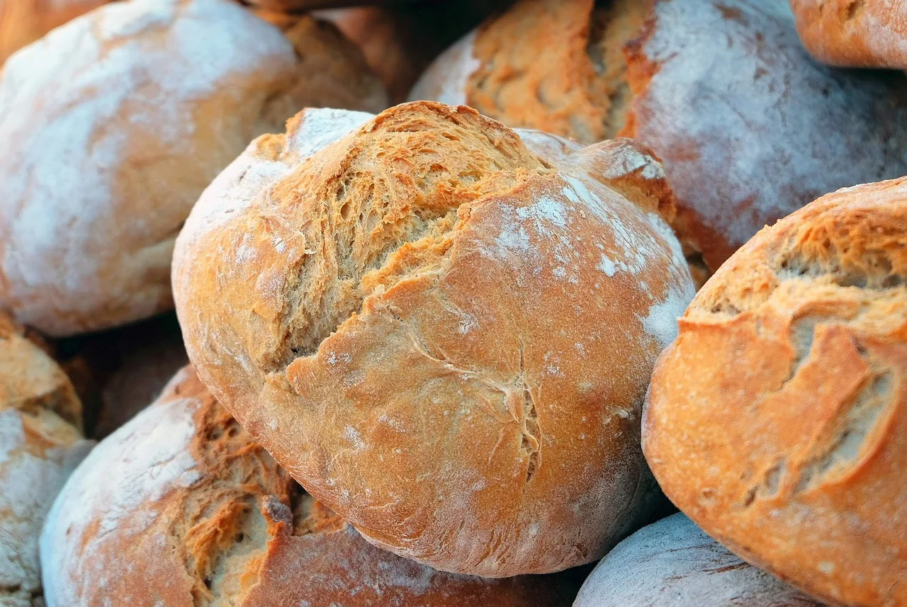 A close-up of crusty, golden artisan bread loaves dusted with flour
